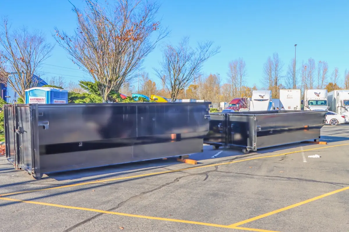 Professional dumpster rental service with roll-off container on residential driveway in East Cleveland